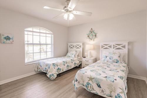 Un dormitorio con dos camas y un ventilador de techo. en 1395 Marco Island, en Marco Island
