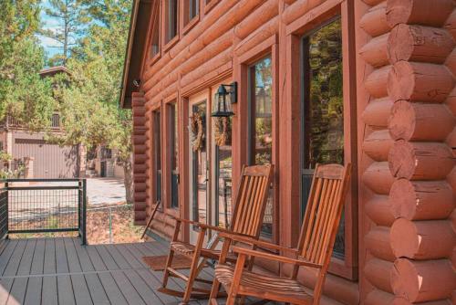 two chairs sitting on the porch of a house at Charming Log AFrame in Pine in Pine