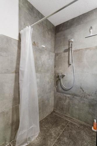 a shower with a white shower curtain in a bathroom at Villa Mia Filomena in Sevid