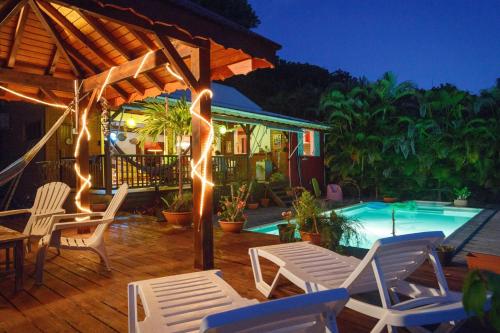 サンタンヌにあるVilla moderne avec piscine à Sainte-Anne 154 m² vue merの- パティオ(椅子付)、夜間のスイミングプール