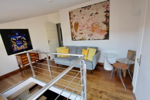 salon z niebieską kanapą i żółtymi poduszkami w obiekcie Ravissant loft dans le centre de Saint-Tropez w Saint-Tropez