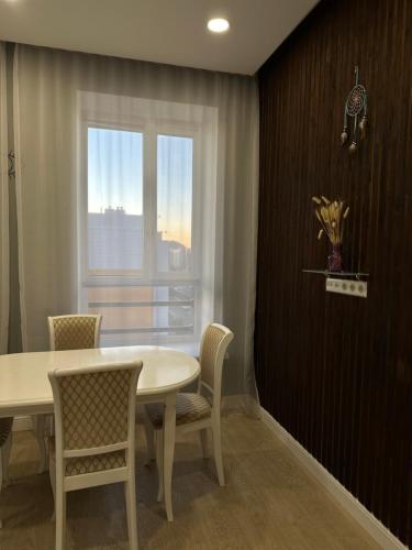 a dining room with a table and chairs and a window at Your comfortable home in Prigorodnyy
