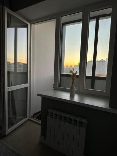 a room with windows with a view of the city at Your comfortable home in Prigorodnyy