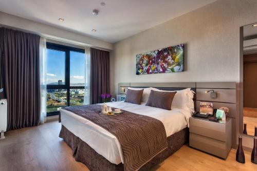 a bedroom with a large bed and a large window at Fraser Place Antasya Istanbul in Istanbul
