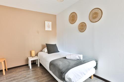 a bedroom with a bed with white sheets at Au nid des remparts à Eguisheim in Eguisheim