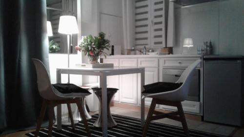 une cuisine avec une table, deux chaises et une table dans l'établissement La Pépite, à Neuilly-sur-Seine