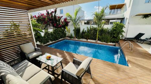 a backyard with a swimming pool and a table and chairs at Luxury Paradise Villa in Paphos