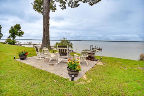 a group of chairs sitting on a patio by the water at Waterfront Gloucester Cottage with Private Boat Dock in Gloucester
