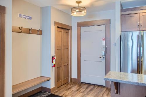 a kitchen with a refrigerator next to a door at Stonegate Resort Unit B102 in Big White