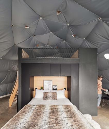 a bedroom with a large bed with a gray ceiling at Dômes Charlevoix in Petite-Rivière-Saint-François
