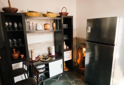 a kitchen with a refrigerator and shelves with dishes at Hospedagem Rancho Fundo in Diamantina