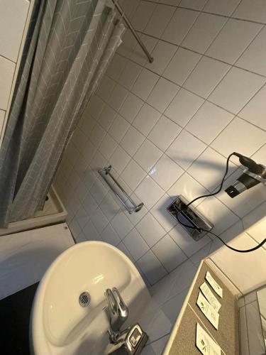 a bathroom with a white sink and a toilet at Hôtel Victoria in Reims