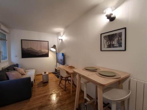 un salon avec une table et un canapé dans l'établissement Studio calme et lumineux près de la gare, à Toulouse