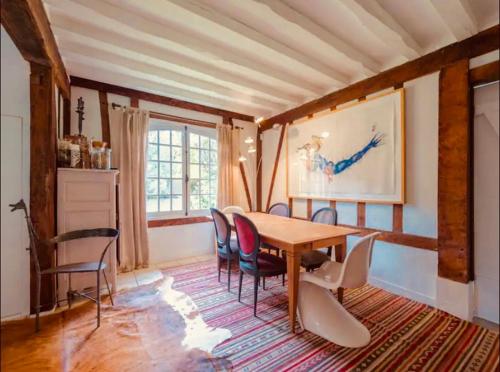 une salle à manger avec une table et des chaises en bois dans l'établissement Maison au bord de la Seine, à Vatteville