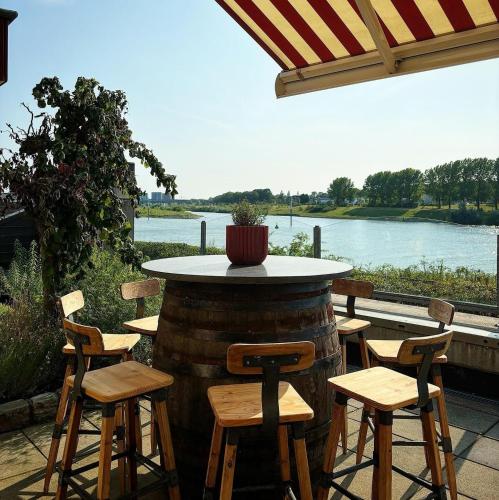 a table and chairs on a patio with a view of a river at Valuas in Venlo