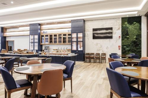 a dining room with tables and chairs and a cafeteria at Hotel Kindermann Chapecó - Hotel Novo in Chapecó