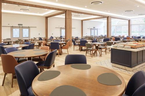 a large room with tables and chairs and windows at Hotel Kindermann Chapecó - Hotel Novo in Chapecó