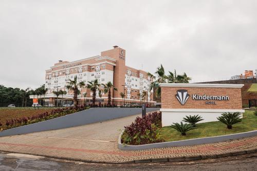 a building with a sign in front of it at Hotel Kindermann Chapecó - Hotel Novo in Chapecó