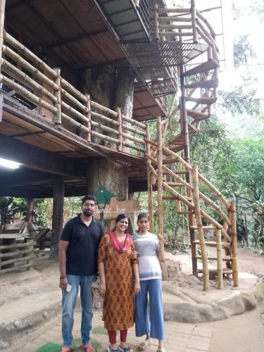 a group of three people standing in front of a building at Jungle Tree House Munnar in Munnar