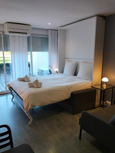 une chambre avec un grand lit avec une grande fenêtre dans l'établissement Le Birdy, terrasse, wifi, clim, à La Grande Motte