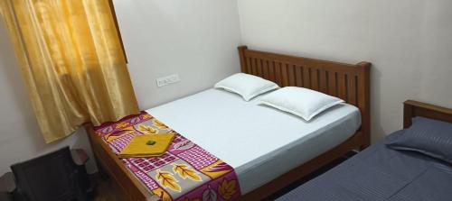 a small bedroom with a bed and a window at KPR Residency Near Isha - Adiyogi in Alāndurai