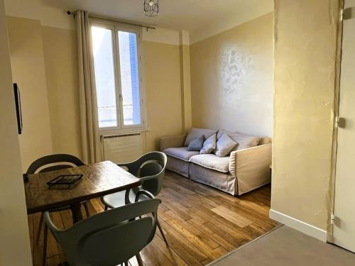 un salon avec une table et un canapé dans l'établissement Appartement Pierre Marty T2 centre-ville Aurillac, à Aurillac