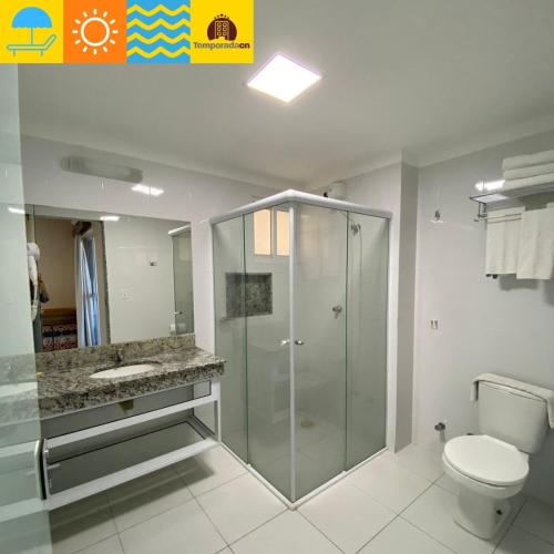 a bathroom with a glass shower and a toilet at Piazza diRoma com acesso ao Acqua Park e Splash - Temporada CN Adriele in Caldas Novas