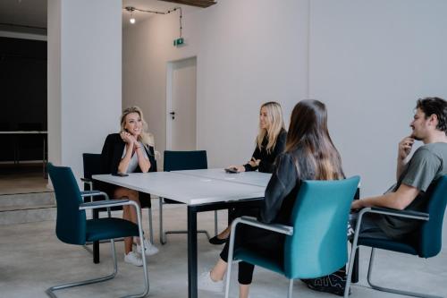 a group of people sitting around a table in a room at Továrna Vír in Vír