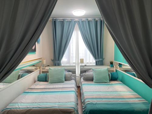 a room with two beds in front of a window at White Turquoise -2 Bedrooms Apartment- in Bangkok