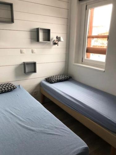 une chambre avec deux lits et une fenêtre dans l'établissement Résidence L'Ours Blanc - maeva Home - Appartement 3 pièces 6 personnes - Exclusive - super Home MAE-5741, à Huez