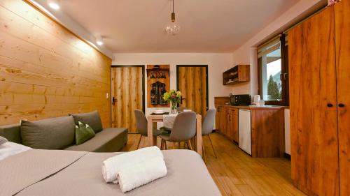 a room with a bed and a table and a kitchen at Willa Magdalena in Sromowce Niżne