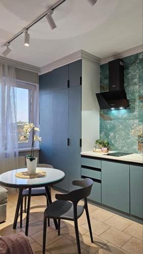 a kitchen with a table and two chairs and a counter at Blue Apartment in Mukacheve