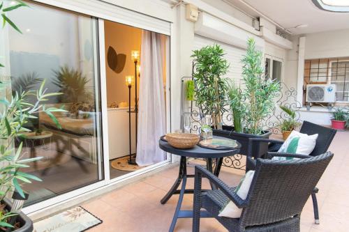 un patio avec une table, des chaises et des plantes dans l'établissement Cosy studio bord de mer, à Canet