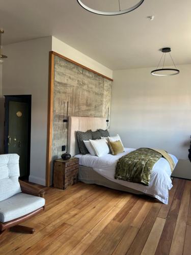 a bedroom with a large bed and a chair at The Advocate in Martinborough 