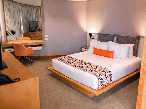 a hotel room with a large bed and a desk at Hotel Humboldt in Los Mecedores