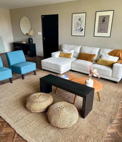 ein Wohnzimmer mit einem weißen Sofa und blauen Stühlen in der Unterkunft Casa Figari, Carrasco, divina zona cerca de la rambla in Montevideo