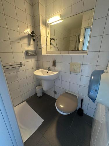 a bathroom with a sink and a toilet and a mirror at Hôtel Victoria in Reims