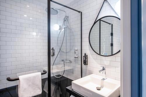 a white bathroom with a sink and a mirror at ibis Tbilisi Airport in Tbilisi City