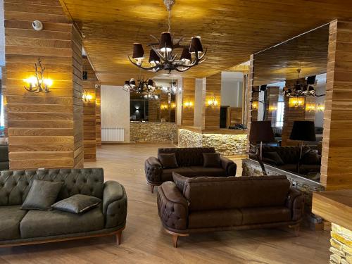 a living room with leather furniture and a chandelier at Avelov Art Studio in Pamporovo