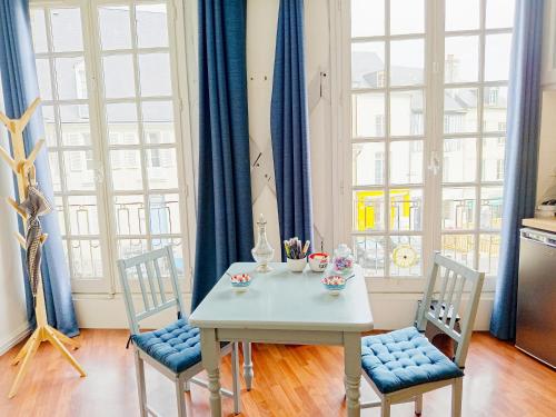 une salle à manger avec une table blanche et deux chaises dans l'établissement Le magnifique en plein centre historique, au Mans