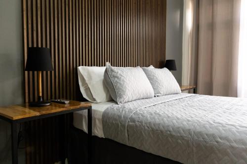 a bedroom with a bed with a wooden headboard at Hotel Boutique Bueso in Villanueva