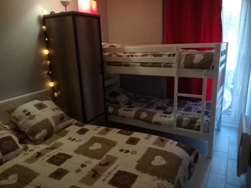 - une chambre avec deux lits superposés et un lit dans l'établissement Appartement aux Angles, aux Angles