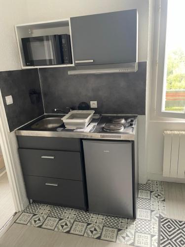 une petite cuisine avec un évier et une cuisinière dans l'établissement Appartement cosy proche gare, à Angoulême