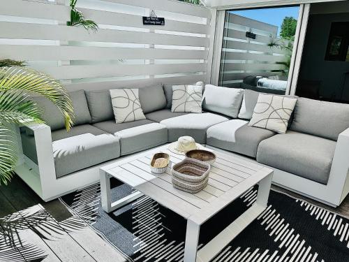 a living room with a couch and a table at Shell Beach Splendide 2 chambres sur la plage in Baie Nettle