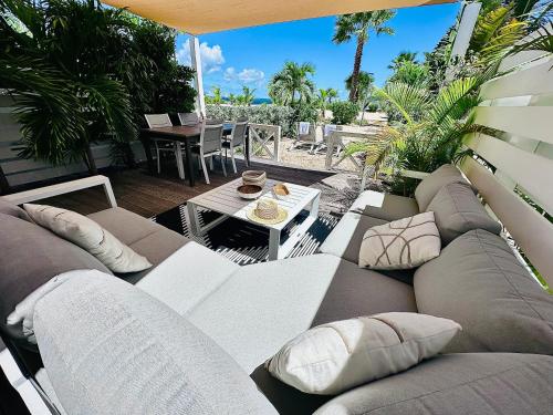 a living room with a couch and a table at Shell Beach Splendide 2 chambres sur la plage in Baie Nettle