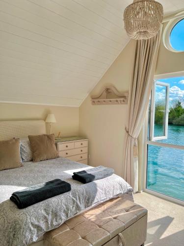 a bedroom with a bed and a large window at Herons Hideout in South Cerney