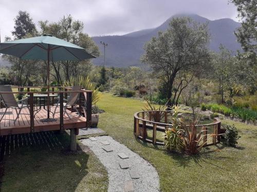 a patio with a table and an umbrella at At theBlueHouse in Stormsrivier