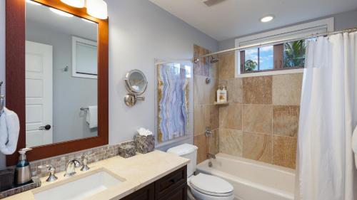 a bathroom with a sink toilet and a mirror at SEA GLASS Stunning 3BR KaMilo Home with Heated Pool and Best View in Waikoloa