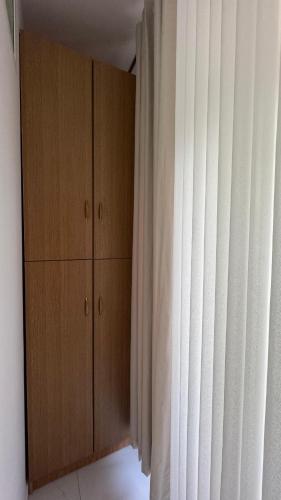 a bedroom with a cabinet and a curtain at Angel's Studio Apartments in Tirana