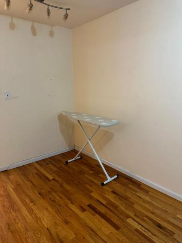 a table in a room with a white wall at Nwk 457 RM 111-A in Newark